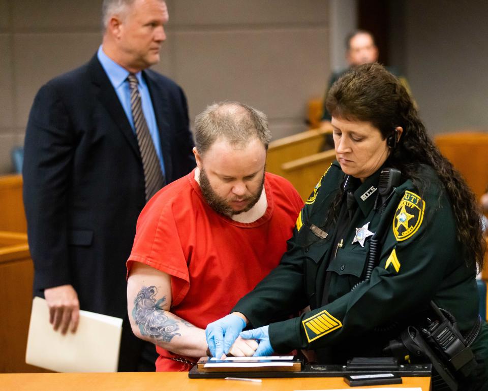 Bailiff Tracy Kugler fingerprints Michael Wayne Jones after his sentencing Friday.