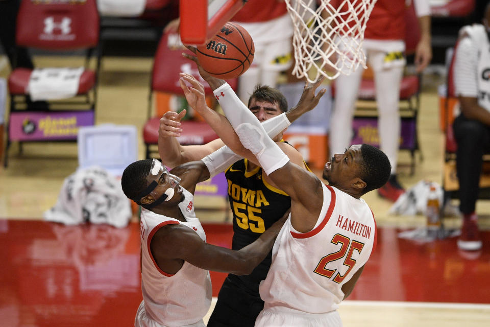 Maryland guard Darryl Morsell (11) and forward Jairus Hamilton (25) battle for the ball with Iowa center Luka Garza (55) during the first half of an NCAA college basketball game, Thursday, Jan. 7, 2021, in College Park, Md. (AP Photo/Nick Wass)