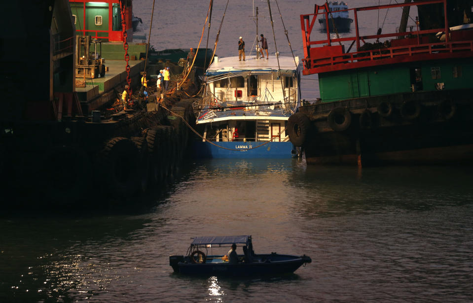 Workers check on a salvaged boat which sank previous night after colliding with a ferry near Lamma Island, off the southwestern coast of Hong Kong Island Tuesday, Oct. 2, 2012. The boat packed with revelers on a long holiday weekend sank, killing nearly 40 people and injuring dozens, authorities said. (AP Photo/Kin Cheung)