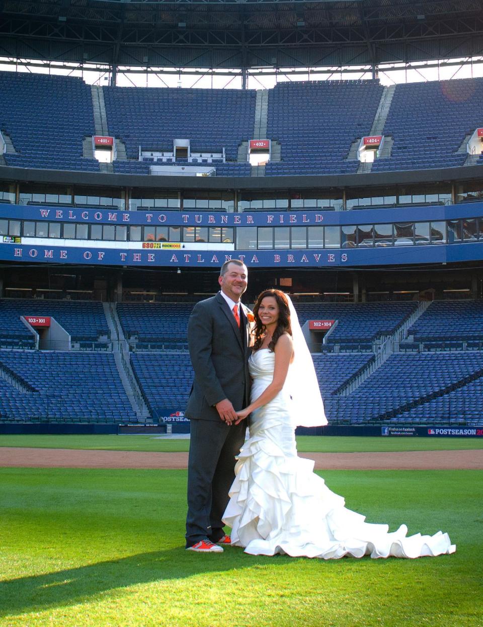 This Nov. 3, 2012 photo released courtesy of Trisha Benzine shows Nick and Trisha Benzine at their wedding held at Turner Field in Atlanta. (AP Photo/Graceology Photography)