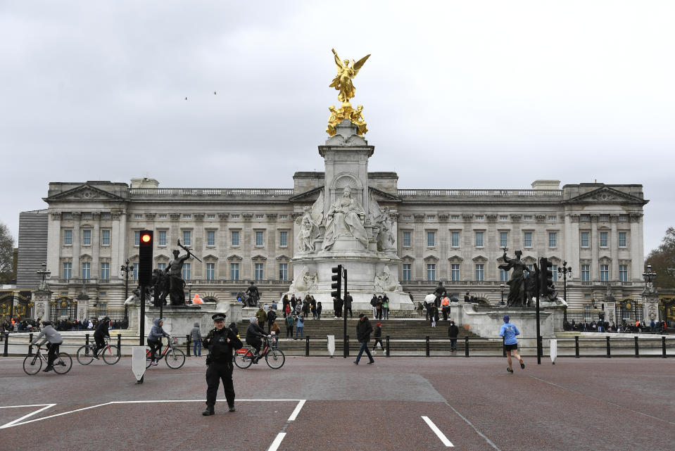 A police officer patrols around the Queen Victoria Memorial outside Buckingham Palace in London, a day after the death of Britain's Prince Philip, Saturday, April 10, 2021. Britain's Prince Philip, the irascible and tough-minded husband of Queen Elizabeth II who spent more than seven decades supporting his wife in a role that mostly defined his life, died on Friday. (AP Photo/Alberto Pezzali)