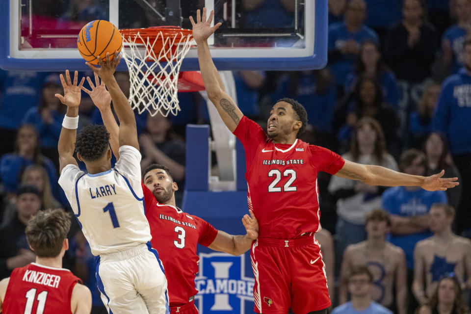 Illinois State guard Dalton Banks (3) and forward Kendall Lewis (22) attempt to block a shot by Indiana State guard Julian Larry (1) during the first half of an NCAA college basketball game Tuesday, Feb. 13, 2024, in Terre Haute, Ind. (AP Photo/Doug McSchooler)