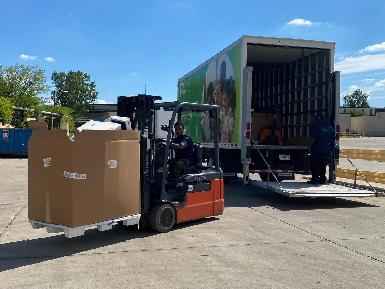 Workers at human-I-T unload donated computer equipment from the city of Detroit on Aug. 10, 2022