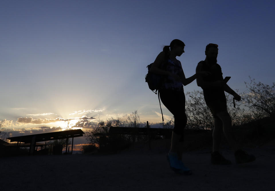 Hikers hit the trail at sunrise to beat the heat Tuesday, July 24, 2018 in Phoenix. Much of Arizona and parts of California, Arizona and Utah are under an excessive heat watch during a week that forecasters say could prove to be the hottest of the year. (AP Photo/Matt York)