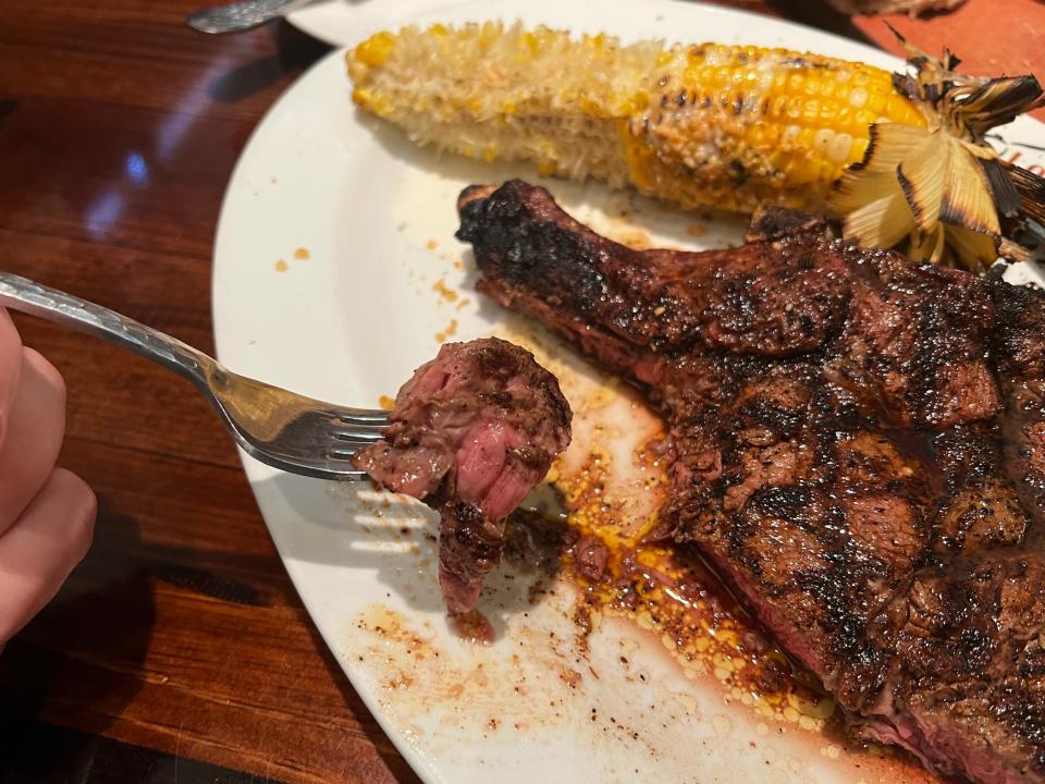 A Longhorn Steakhouse bone-in ribeye cooked medium-rare