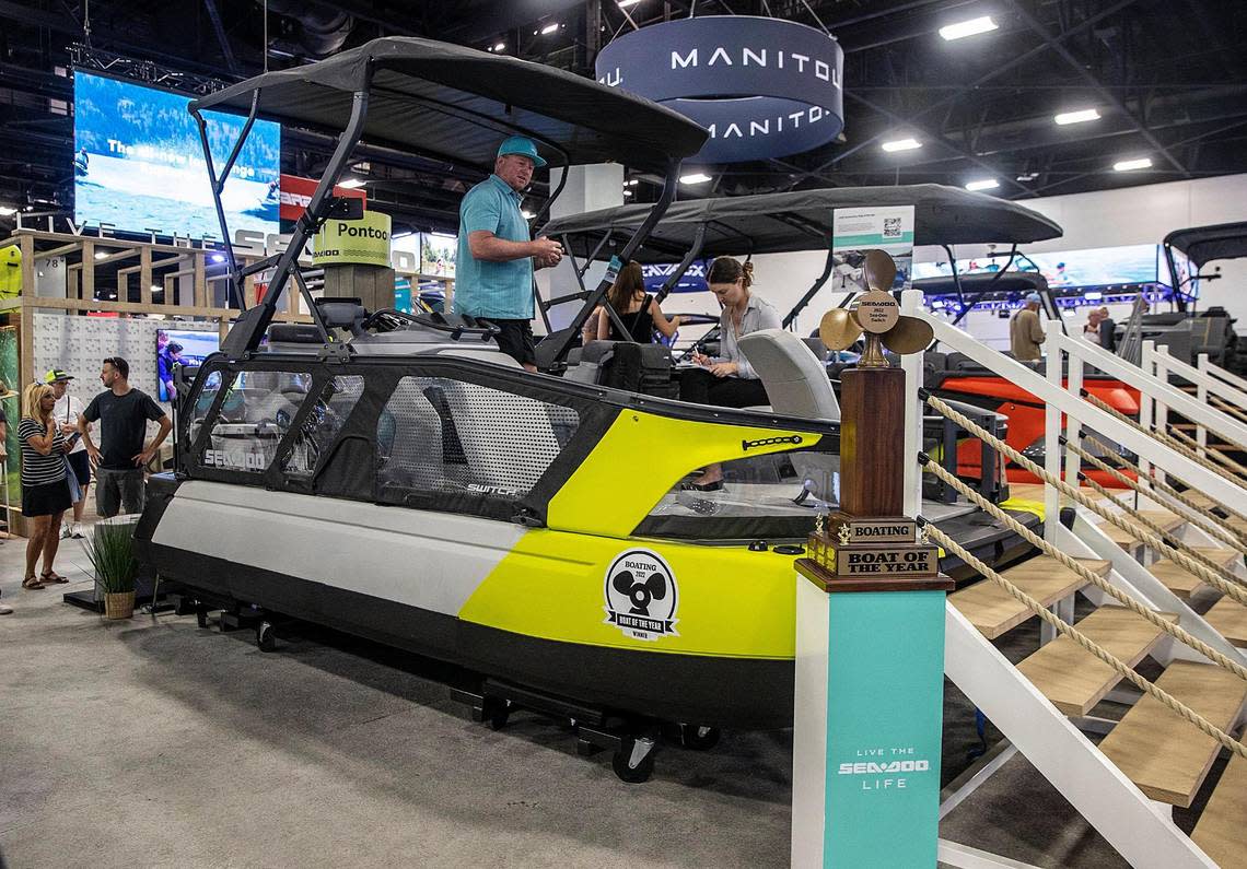 Tim McKercher, media relations manager with Sea-Doo, shows Miami Herald reporter Anna Jean Kaiser the Sea-Doo Switch Sport Pontoon vessel with a starting price of $27,399 at the Miami International Boat Show on Feb. 17, 2023.