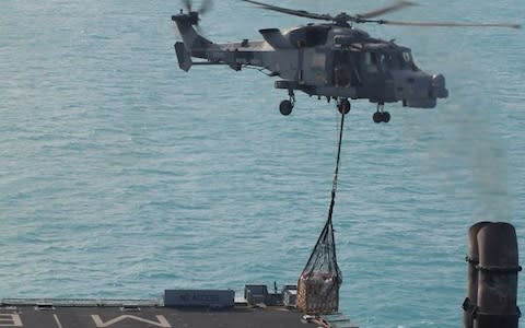 a Royal Navy Wildcat from 815 NAS (Naval Air Squadron) lifting off from the flight deck of RFA Mounts Bay with vital stores for Sandy Bay Village beach, Anguilla - Credit:  Royal Navy