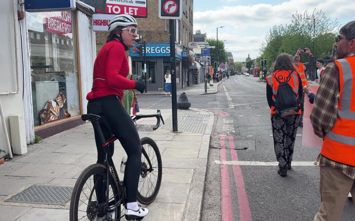 Man in lycra, on bike, stops on pavement to talk to Just Stop Oil protesters - Tom Bowles