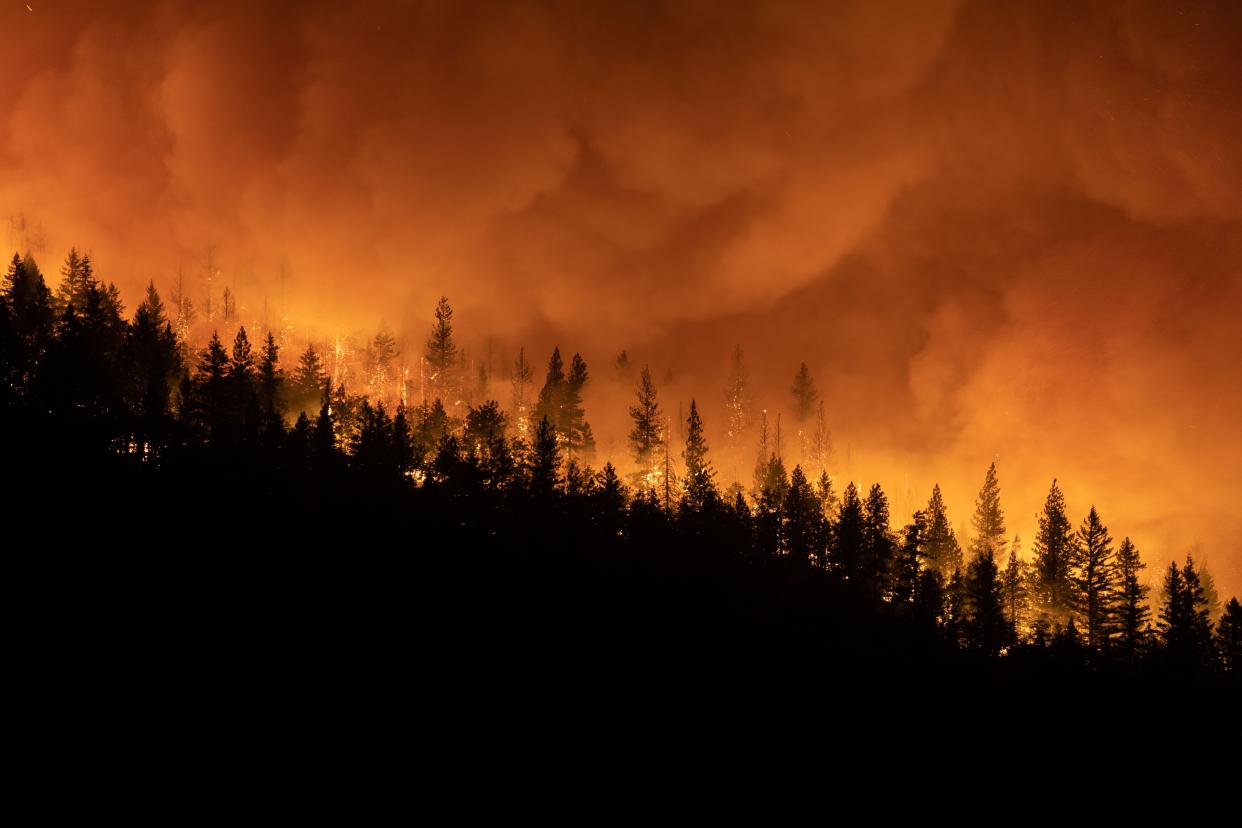 The Dixie Fire burns on a mountain ridge sending embers into the air on Aug. 5, 2021, in Greenville, Calif.