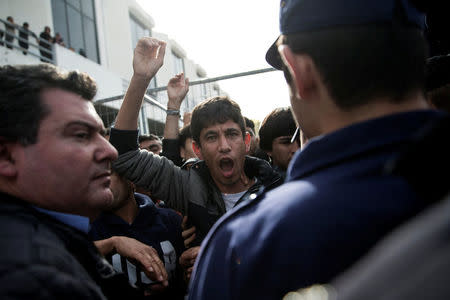 Refugees and migrants, most of them Afghans, shout slogans while blocking the entrance of the refugee camp at the disused Hellenikon airport as police officers try to disperse them, in Athens, Greece, February 6, 2017. REUTERS/Alkis Konstantinidis