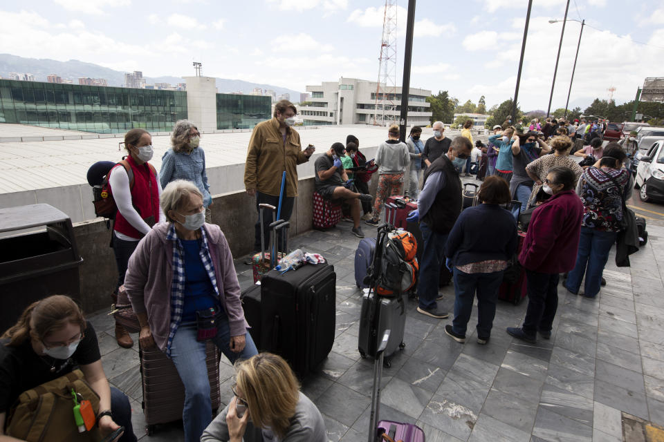 Travelers wait to take a charter flight coordinated by the U.S. embassy at La Aurora airport in Guatemala City, Monday, March 23, 2020. American citizens stranded abroad because of the coronavirus pandemic are seeking help in returning to the United States. (AP Photo/Moises Castillo)