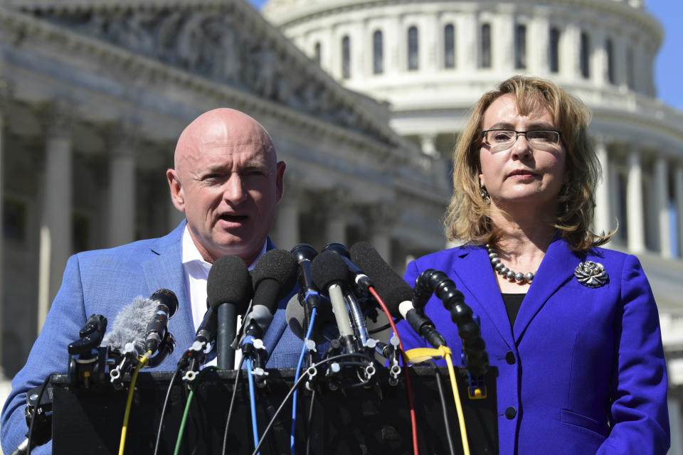 FILE- In this Oct. 2, 2017, file photo former Rep. Gabrielle Giffords, D-Ariz., right, listens as her husband Mark Kelly, left, speaks on Capitol Hill in Washington. Kelly is kicking off his U.S. Senate campaign Saturday, Feb. 23, 2019, with a rally in Tucson (AP Photo/Susan Walsh, File)