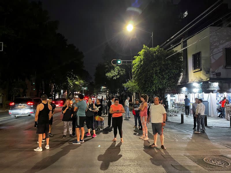 People stand on the street during a quake alarm in Mexico City