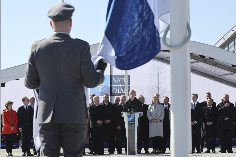 NATO Secretary General Jens Stoltenberg, center, speaks as Military personnel prepare to raise the flag of Finland during a flag raising ceremony on the sidelines of a NATO foreign ministers meeting at NATO headquarters in Brussels, Tuesday, April 4, 2023. Finland joined the NATO military alliance on Tuesday, dealing a major blow to Russia with a historic realignment of the continent triggered by Moscow's invasion of Ukraine. (AP Photo/Geert Vanden Wijngaert)