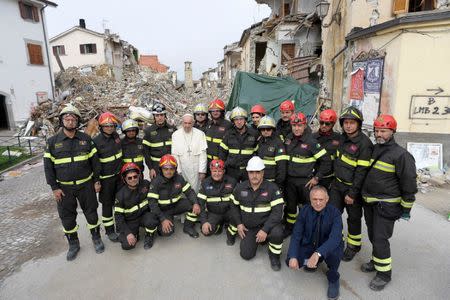 Pope Francis poses with firefighters in Amatrice, Italy, October 4, 2016. REUTERS/Osservatore Romano/Handout via Reuters