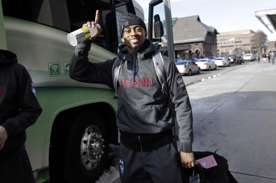 Connecticut's Ryan Boatright gestures toward members of the media as he boards a bus to depart to Dallas following an NCAA college basketball team workout Tuesday, April 1, 2014, in Storrs, Conn. UConn will play Florida in a Final Four game on Saturday in Dallas. (AP Photo/Steven Senne)