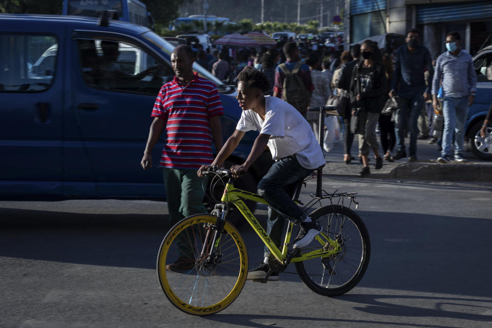 An Ethiopian rides his bicycle on a street in the capital Addis Ababa, Ethiopia Thursday, Nov. 5, 2020. Ethiopia's powerful Tigray region asserts that fighter jets have bombed locations around its capital, Mekele, aiming to force the region "into submission," while Ethiopia's army says it has been forced into an "unexpected and aimless war." (AP Photo/Mulugeta Ayene)