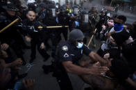 Police officers and protesters clash near CNN Center, Friday, May 29, 2020, in Atlanta, in response to George Floyd's death in police custody in Minneapolis on Memorial Day. The protest started peacefully earlier in the day before demonstrators clashed with police. (AP Photo/Mike Stewart)