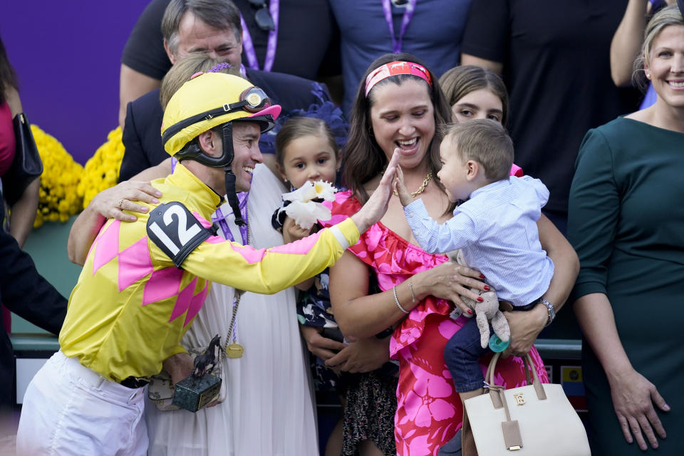 Flavien Prat, left, celebrates with members of the owner group Wise Racing after riding Hard To Justify to win the Breeders' Cup Juvenile Fillies Turf horse race Friday, Nov. 3, 2023 at Santa Anita Park in Arcadia, Calif. (AP Photo/Ashley Landis)