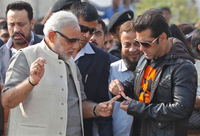 FILE PHOTO: Bollywood actor Salman Khan (R) ties a band-aid on the finger of Narendra Modi during a kite flying festival in Ahmedabad