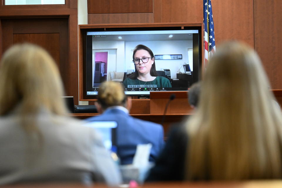 Jennifer Howell is seen on a screen testifying in a previously recorded video at the Fairfax County Circuit Courthouse in Fairfax, Va., Tuesday, May 24, 2022. Depp sued his ex-wife Amber Heard for libel in Fairfax County Circuit Court after she wrote an op-ed piece in The Washington Post in 2018 referring to herself as a "public figure representing domestic abuse." (Jim Watson/Pool photo via AP)