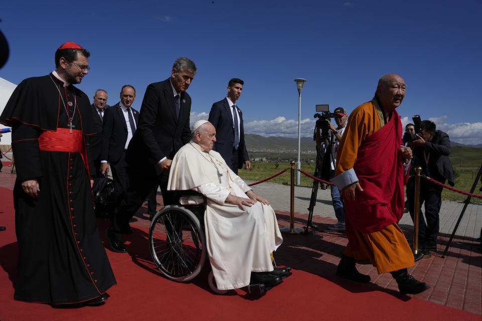 Pope Francis on a wheelchair leaves with Apostolic Prefect of Ulaanbaatar Cardinal Giorgio Marengo, left, and Gabju Demberel Choijamts, right, abbot of the Buddhists' Gandantegchinlen Monastery in Ulaanbaatarat, at the end of a meeting with religious leaders at the Hun Theatre some 15 kilometers south of the Mongolian capital Ulaanbaatar, Sunday, Sept. 3, 2023. Pope Francis has praised Mongolia's tradition of religious freedom dating to the times of founder Genghis Khan during the first-ever papal visit to the Asian nation. (AP Photo/Ng Han Guan)