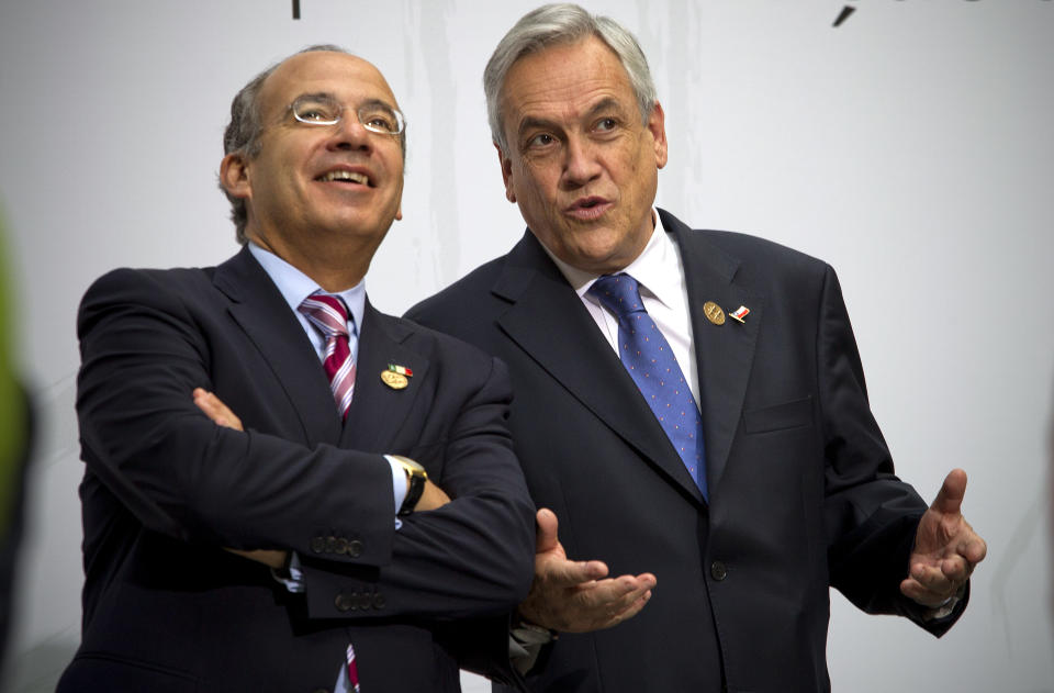 Chile's President Sebastian Pinera, right, and Mexico's President Felipe Calderon, left, talk as they pose for a photo at the XXII Iberoamerican summit in the southern Spanish city of Cadiz, Saturday, Nov. 17, 2012. Spain's King Juan Carlos opened the annual Iberoamerican summit, which brings together the heads of Spain and Portugal and the leaders of Latin America to discuss political issues and arrange business deals. (AP Photo/Miguel Angel Morenatti)