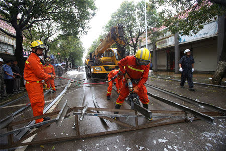 Rescue workers try to remove steel bars from a street as Typhoon Megi hits Xiamen, Fujian province, China, September 28, 2016. REUTERS/Stringer