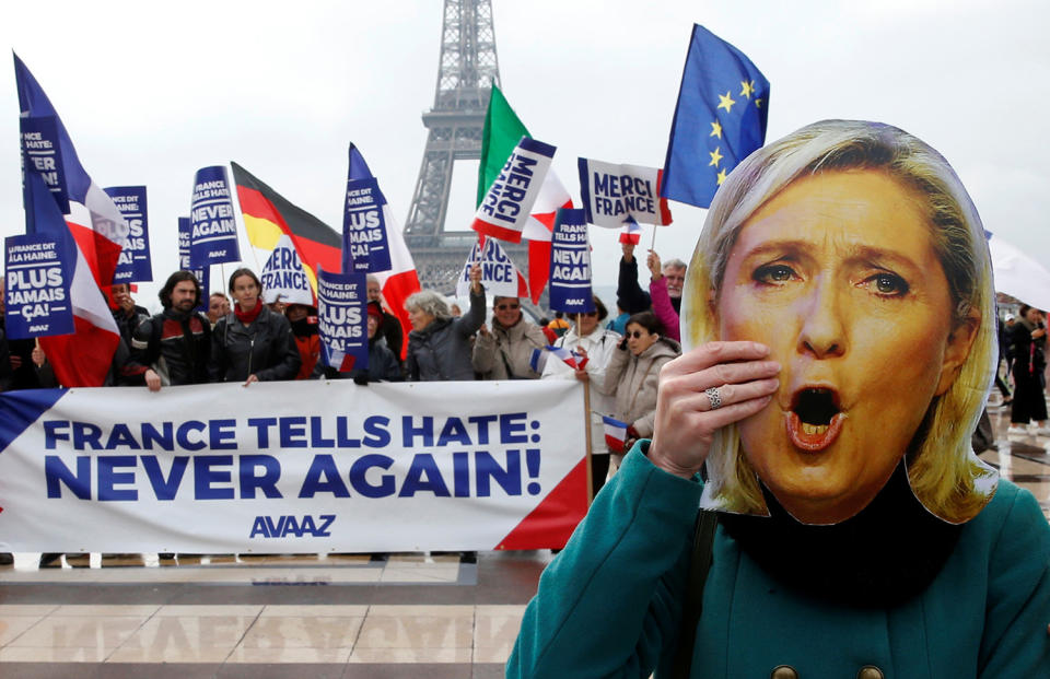 <p>A person holds a mask of France’s National Front (FN) presidential candidate Marine Le Pen, as people gather with French and European Union flags near the Eiffel Tower the day after France’s presidential elections, in Paris, May 8, 2017. (Pascal Rossignol/Reuters) </p>