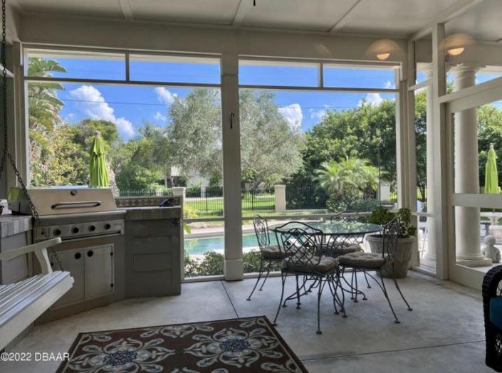 French doors in the kitchen open to the screen porch for grilling and gathering, adding to the indoor-outdoor dining experience.