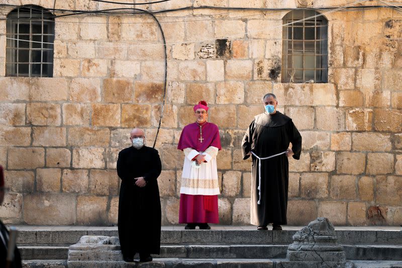 FILE PHOTO: Archbishop Pierbattista Pizzaballa, apostolic administrator of the Latin Patriarchate of Jerusalem stands at the entrance to the Church of the Holy Sepulchre amid coronavirus restrictions in Jerusalem's Old City