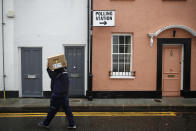 A man carries a box away from a polling station in London, Thursday, Dec. 12, 2019. The general election in Britain on Thursday will bring a new Parliament to power and may lead to a change at the top if Prime Minister Boris Johnson's Conservative Party doesn't fare well with voters. Johnson called the early election in hopes of gaining lawmakers to support his Brexit policy. (AP Photo/Thanassis Stavrakis)