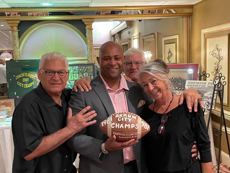 John Wooldridge, center, with Bruce Flossie, left, Ben Flossie and Jeannie Flossie during a celebration of life for coach Tim Flossie. Ben and Bruce are Tim's brothers. Jeannie is Tim's widow. They gave Wooldridge the game ball from the 1981 City Series championship.