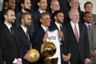 U.S. President Barack Obama holds up a jersey during a ceremony honoring the NBA defending champion San Antonio Spurs basketball team at the White House in Washington January 12, 2015. With him are Manu Ginobili (front L-R), Tony Parker, Cory Joseph, Coach Gregg Popovich and Patty Mills. REUTERS/Kevin Lamarque (UNITED STATES - Tags: POLITICS SPORT BASKETBALL)