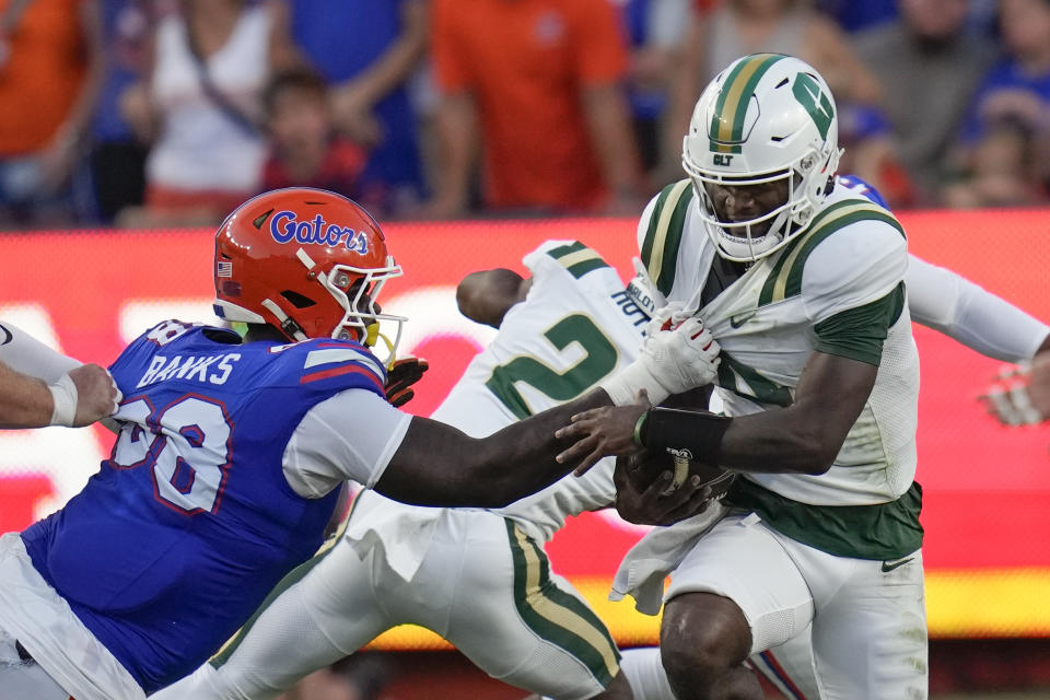 Florida defensive lineman Caleb Banks, left, holds on to Charlotte quarterback Jalon Jones, right, who tries to advance the ball during the first half of an NCAA college football game, Saturday, Sept. 23, 2023, in Gainesville, Fla. (AP Photo/John Raoux)