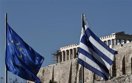 A Greek (R) and an EU flag flutter in front of the temple of the Parthenon, during the takeover ceremony of the six-month rotation of Greece's EU Presidency at Zappeion Hall, in Athens January 8, 2014. REUTERS/Yorgos Karahalis