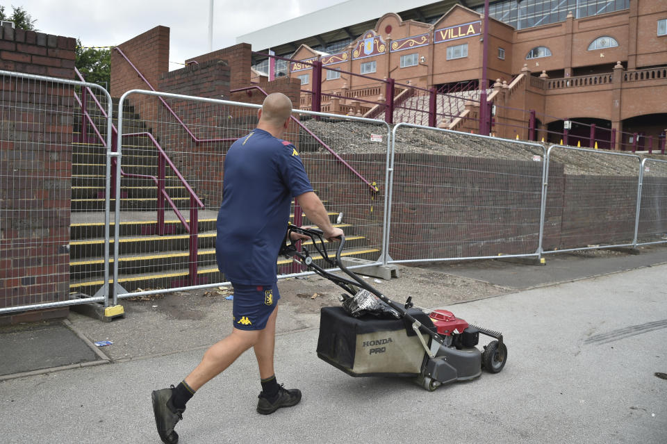 Un empleado de Aston Villa camina alrededor del estadio Villa Park, un día antes del reinicio de la Liga Premier con el partido entre Aston Villa y Sheffield United en Birmingham, Inglaterra, el martes 16 de junio de 2020. (AP Foto/Rui Vieira)