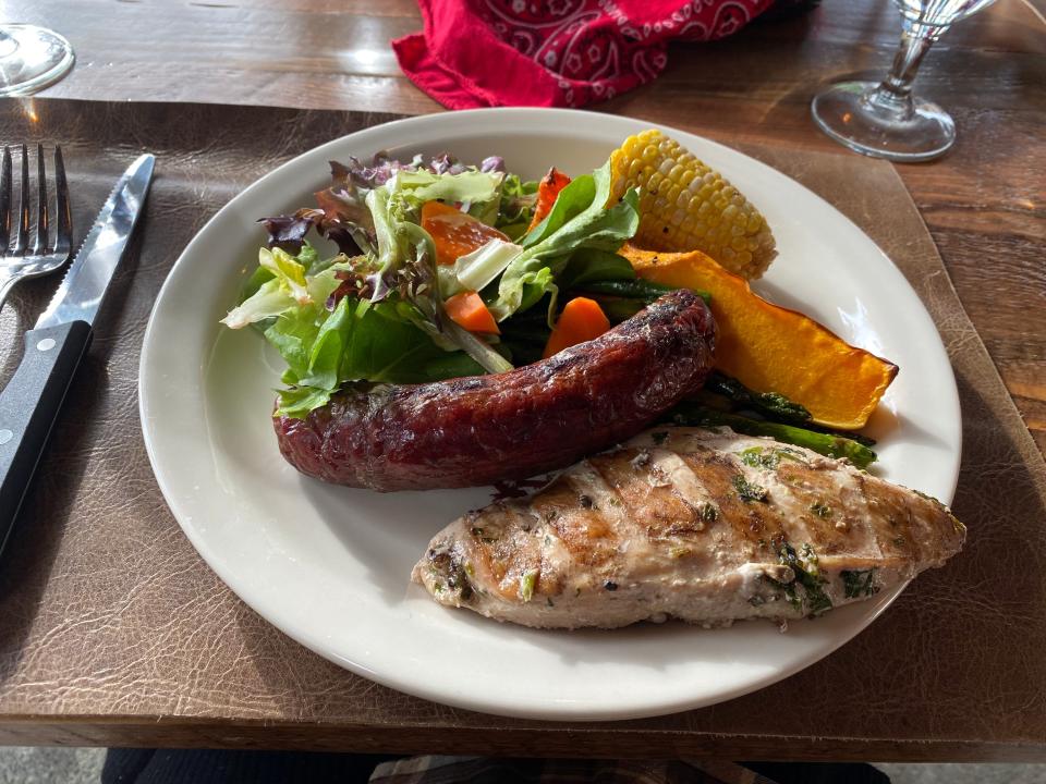 A plate of meat, greens, and vegetables.