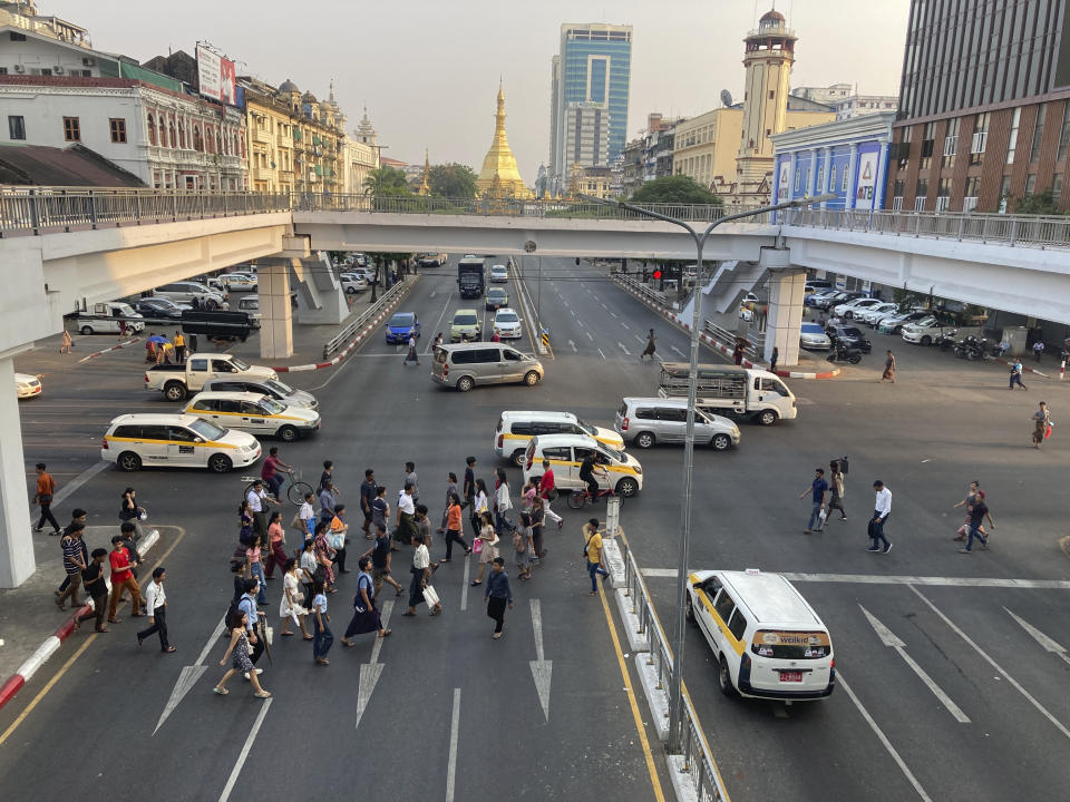 Pedestrians walk cross a road near Sule pagoda im Yangon, Myanmar, Monday, April 29, 2024. (AP Photo)