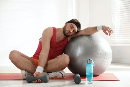 <span class="caption">Becoming 'unfit' happens a lot faster than it takes us to get 'fit'.</span> <span class="attribution"><a class="link " href="https://www.shutterstock.com/image-photo/lazy-young-man-sport-equipment-indoors-1717615618" rel="nofollow noopener" target="_blank" data-ylk="slk:New Africa/ Shutterstock;elm:context_link;itc:0;sec:content-canvas">New Africa/ Shutterstock</a></span>