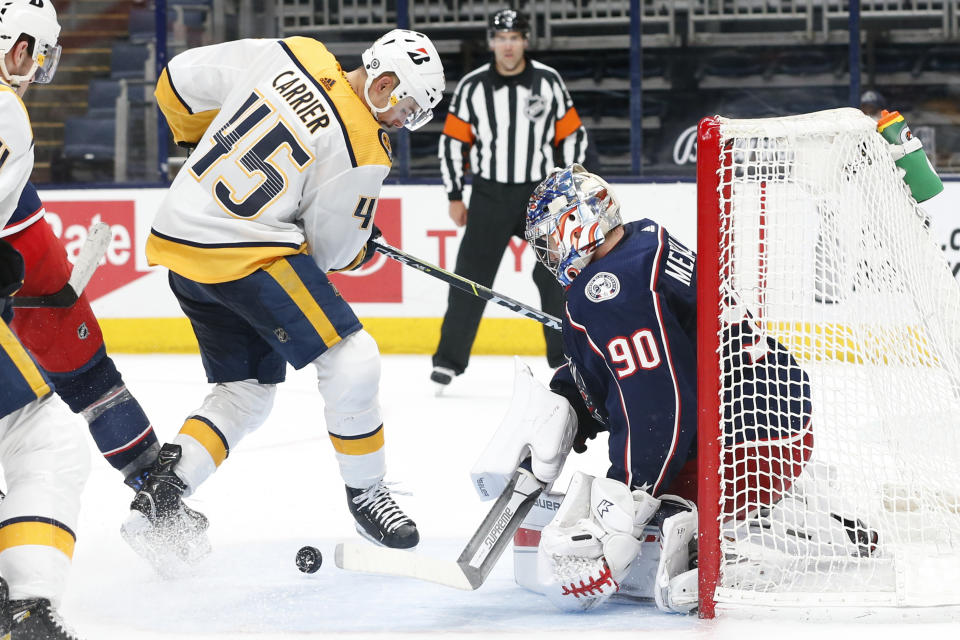 Columbus Blue Jackets' Elvis Merzlikins, right, makes a save against Nashville Predators' Alexandre Carrier during the third period of an NHL hockey game Wednesday, May 5, 2021, in Columbus, Ohio. The Blue Jackets won 4-2. (AP Photo/Jay LaPrete)