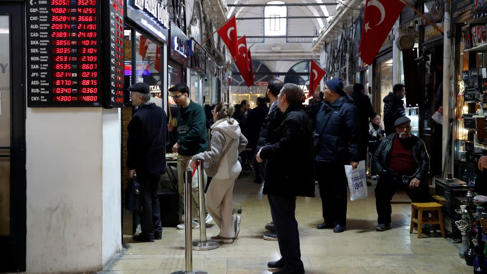 People wait in line outside a currency exchange office at the Grand Bazaar in Istanbul on March 7, 2024. - Dilara Senkaya/Reuters