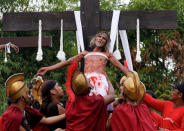 A Catholic devotee is lowered after he was nailed to a wooden cross during Good Friday, in San Fernando City, Pampanga province, Philippines, April 19, 2019. REUTERS/Eloisa Lopez