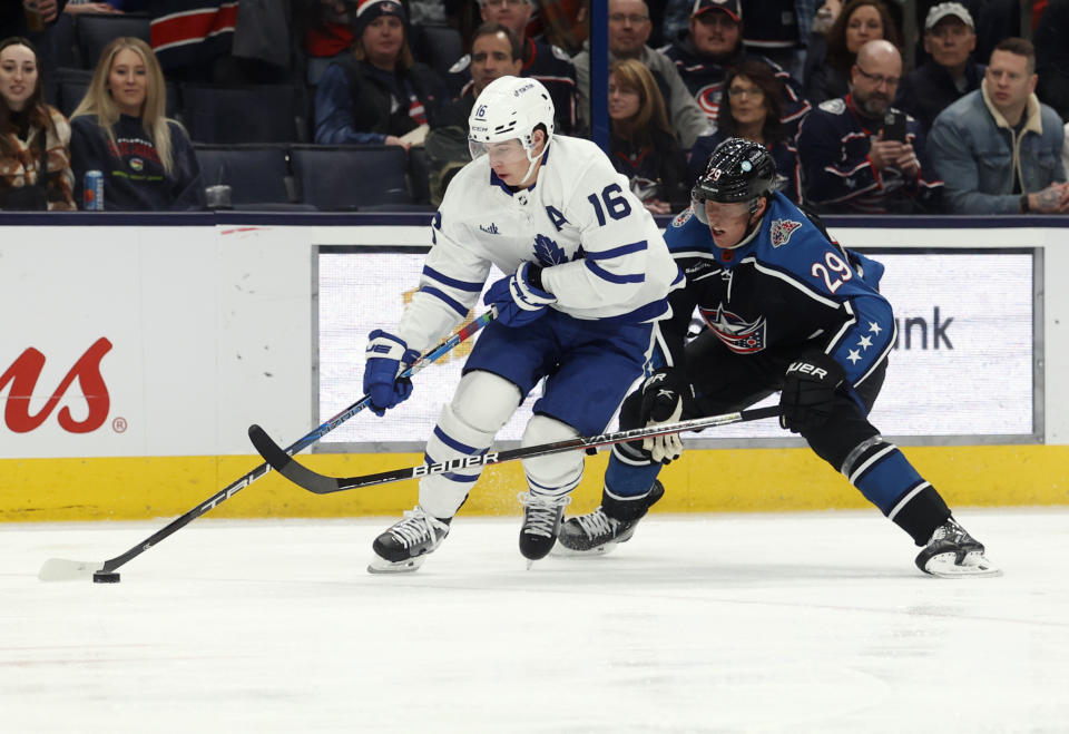 Toronto Maple Leafs forward Mitchell Marner, left, controls the puck in front of Columbus Blue Jackets forward Patrik Laine during the first period of an NHL hockey game in Columbus, Ohio, Friday, Feb. 10, 2023. (AP Photo/Paul Vernon)