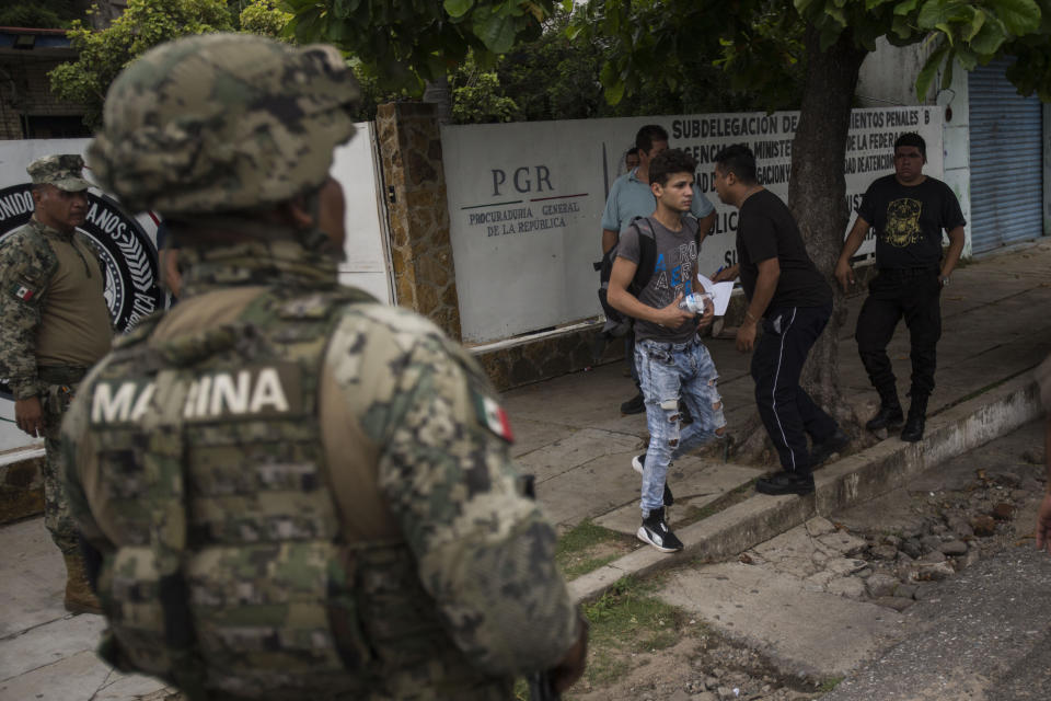 A man without legal permission to be in Mexico leaves an office of the Attorney General before being sent to Tapachula in an immigration van, as members of the National Guard stand watch in Arriaga, Mexico, Sunday, June 23, 2019. Mexico has completed its deployment of 6,000 National Guard agents to help control the flow of migrants headed toward the U.S. and filled immigration agency posts to regulate border crossings, the government said Friday. (AP Photo/Oliver de Ros)