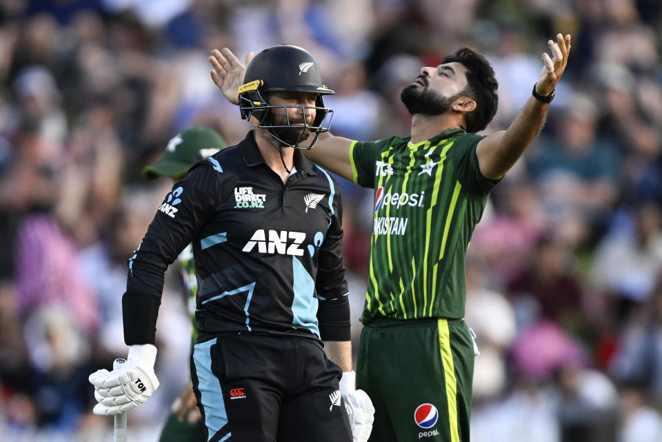 Aamer Jamal of Pakistan celebrates after taking the wicket of New Zealand's Devon Conway, left, during the T20 cricket international between New Zealand and Pakistan at Eden Park in Auckland, New Zealand, Sunday, Jan. 14, 2024. (Andrew Cornaga/Photosport via AP)