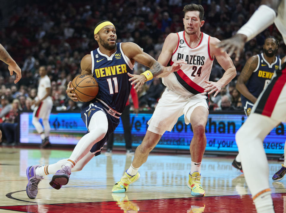 Denver Nuggets forward Bruce Brown (11), left, dribbles past Portland Trail Blazers forward Drew Eubanks (24) during the first half of an NBA basketball game in Portland, Ore., Monday, Oct. 24, 2022. (AP Photo/Craig Mitchelldyer)