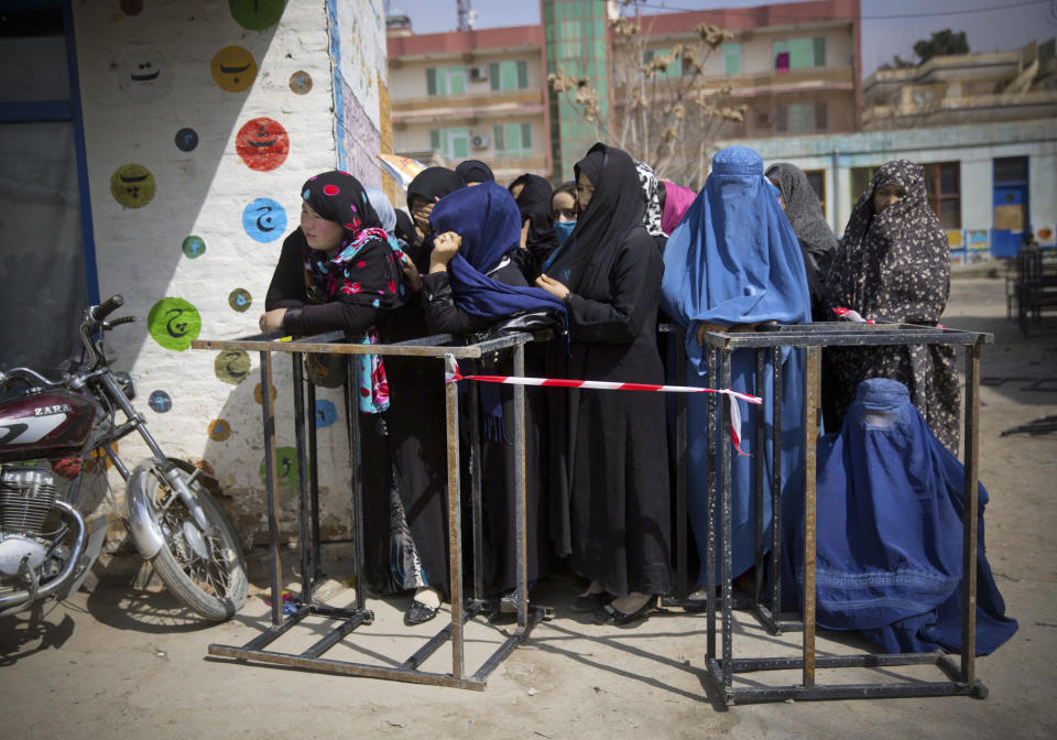 Afghan women wait to get their registration card on the last day of voter registration for the upcoming presidential elections outside a school in Kabul, Afghanistan, Tuesday, April 1, 2014. Elections will take place on April 5, 2014. (AP Photo/Anja Niedringhaus)