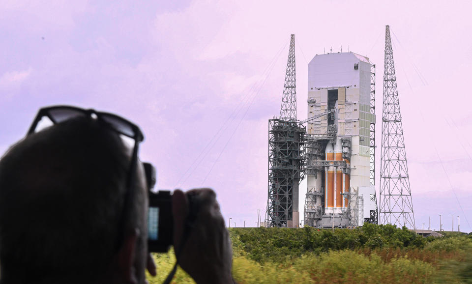 a man photographs a rocket on a launch pad