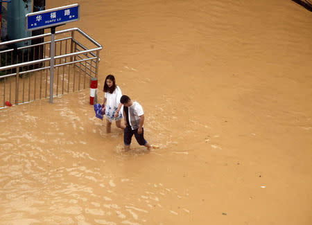 Residents walk at a flooded area as Typhoon Nepartak brings heavy rainfall in Putian, Fujian Province, China, July 9, 2016. Picture taken July 9, 2016. REUTERS/Stringer